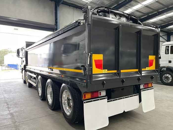 Rear close-up of SITRAK G7 10X4 dump truck showing tailgate and chassis