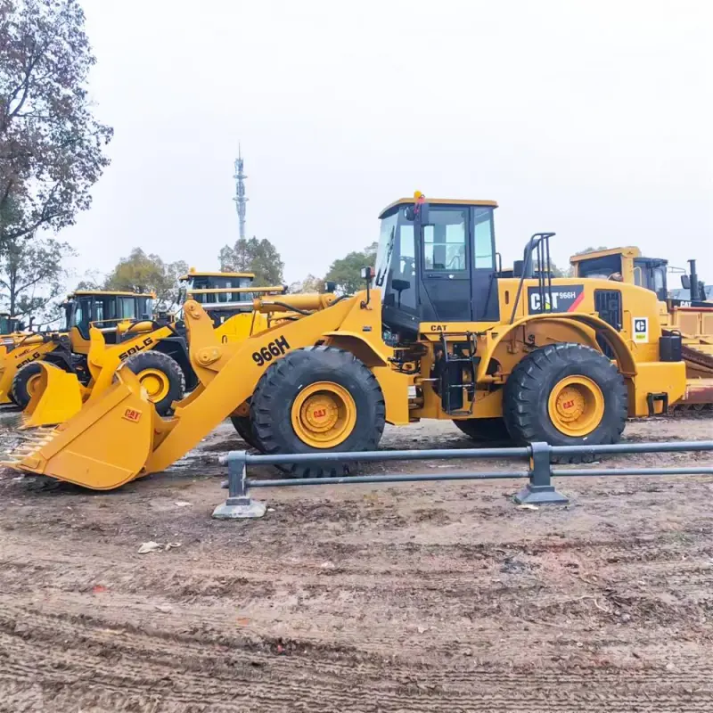 Side view of used CAT 966H wheel loader with articulated steering and heavy-duty tires