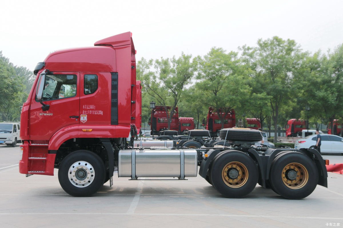 Side view of 6x4 heavy-duty truck showing cabin, tires, and fuel tank.