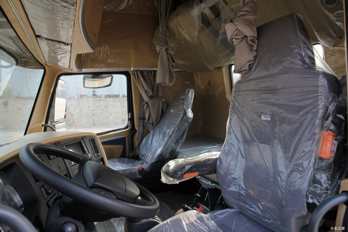 Interior of a tractor truck cabin featuring comfortable driver seats and control panel