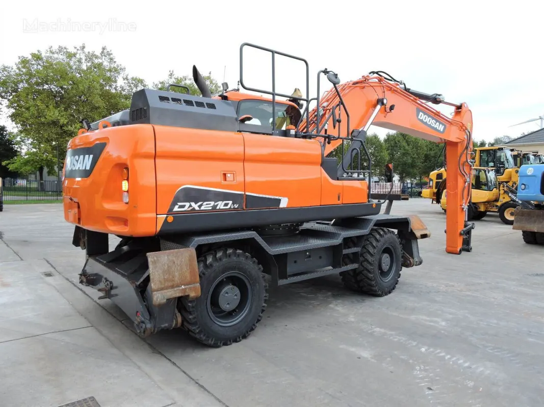 Doosan DX210W wheeled excavator side 3/4 angle with boom fully extended on construction site