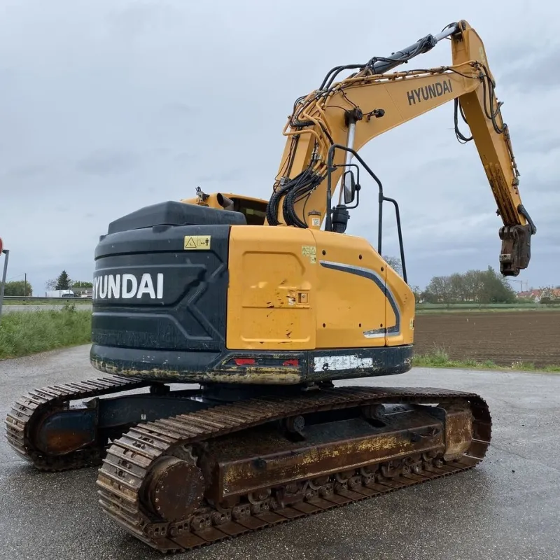 Used Hyundai 235 excavator with arm extended in three-quarter angle on job site