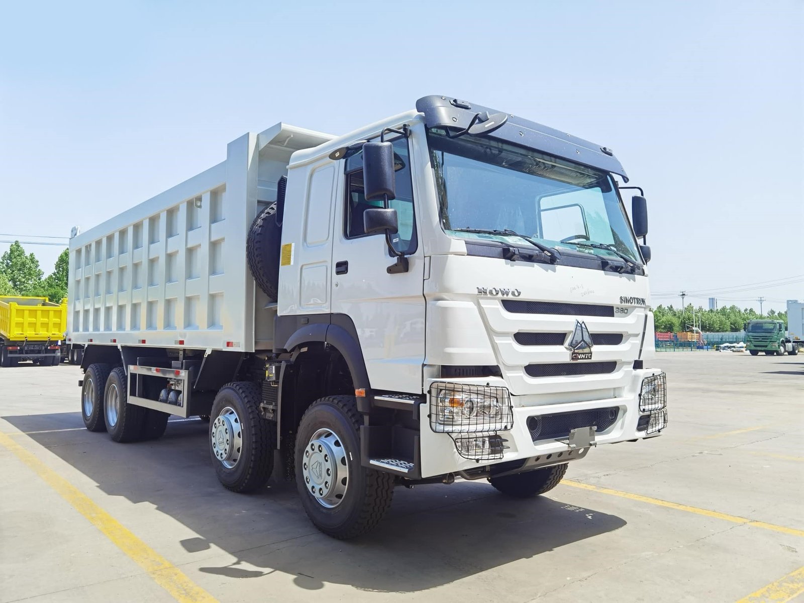 Front view of heavy-duty dump truck cabin focusing on grille and headlights.