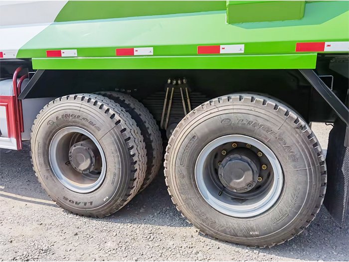 Used FAW J6P 390HP Dump Truck tire close-up with deep tread and heavy-duty steel rim.