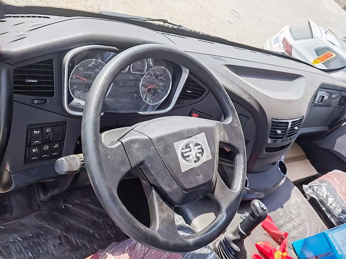 Used FAW J6P 390HP Dump Truck steering wheel close-up with dashboard and control panel.