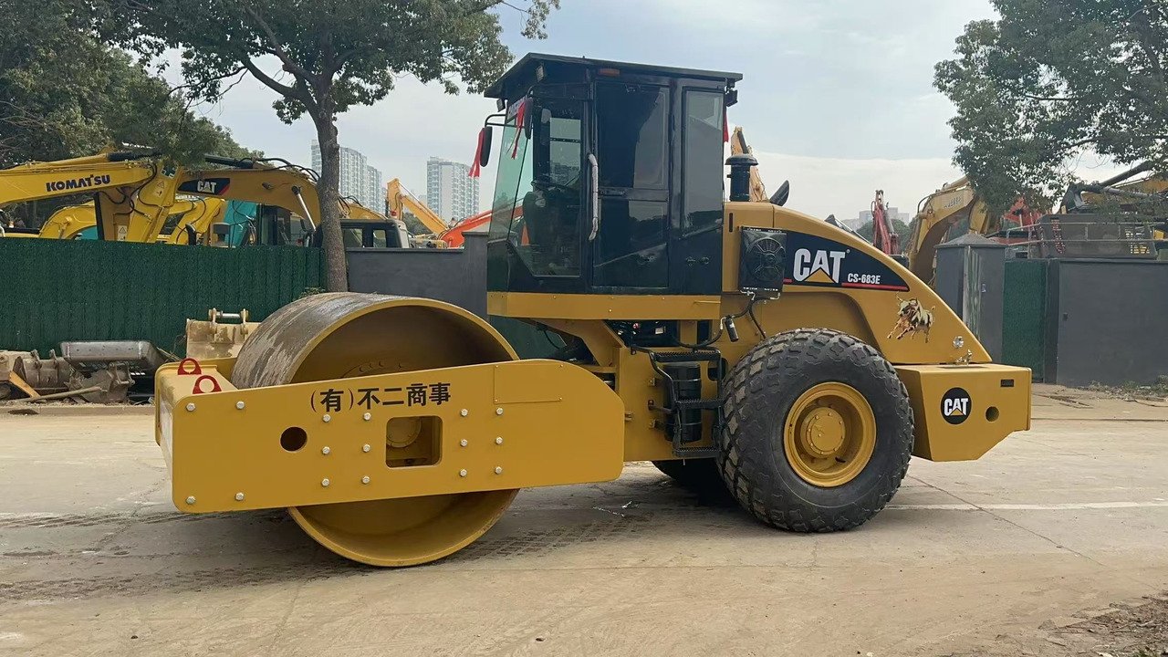 Side view of used CAT CS683E Road Roller, heavy-duty compaction machine