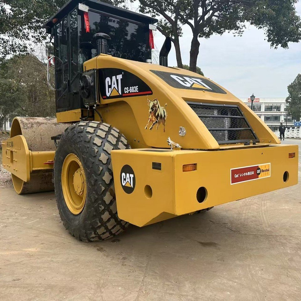 Front 3/4 view of used CAT CS683E Road Roller, showing drum and operator cabin