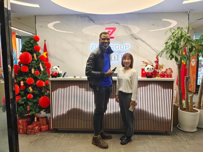 Nigerian loyal clients and ZW Group team at company entrance for HOWO truck and used excavator order.