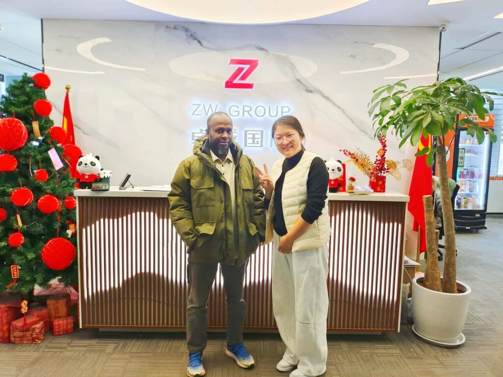 ZW Group sales representative and Chad client at factory for new CAT excavator order.