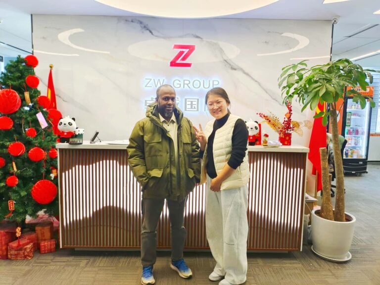 ZW Group sales representative and Chad client at factory for new CAT excavator order.