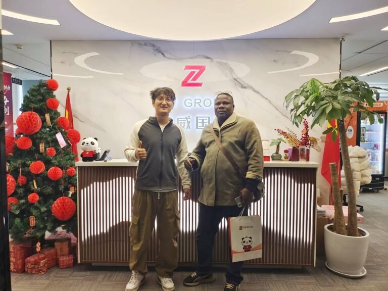 Customers taking a group photo with the ZW team at the company entrance after discussing XCMG wheel loader solutions for Togo.