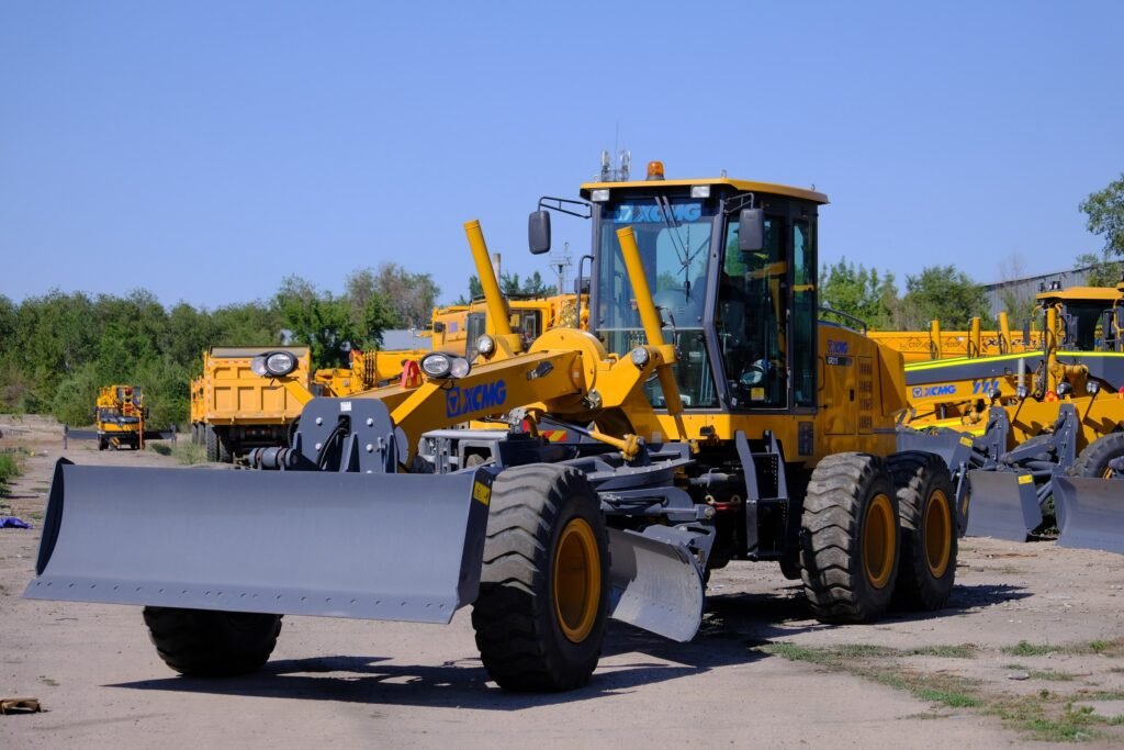 Front view of Brand New XCMG GR215 Motor Grader showing heavy-duty frame, hydraulic blade system, and robust construction for road grading and earthmoving