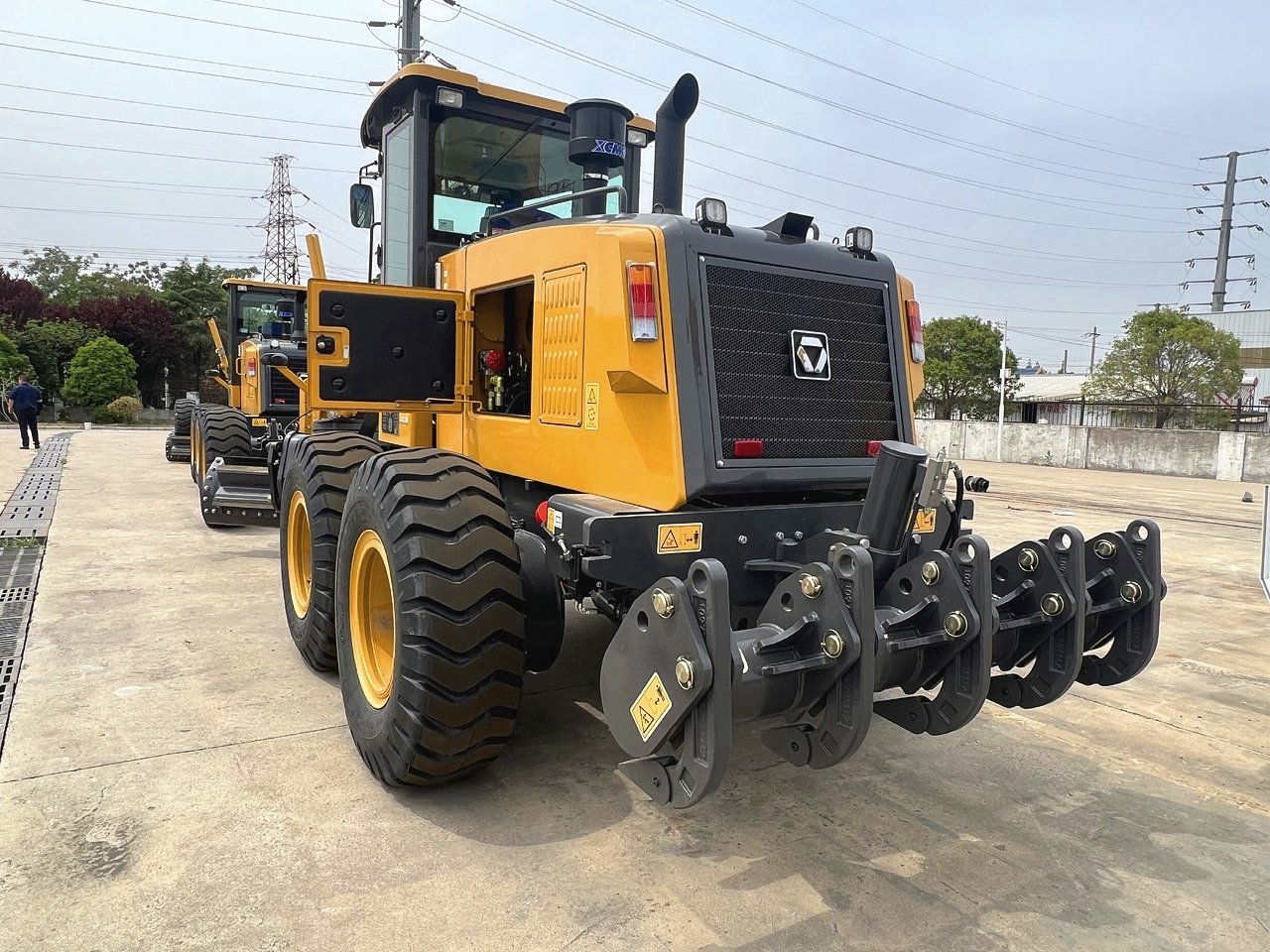 Front three-quarter view of XCMG GR180 motor grader showing blade and cab