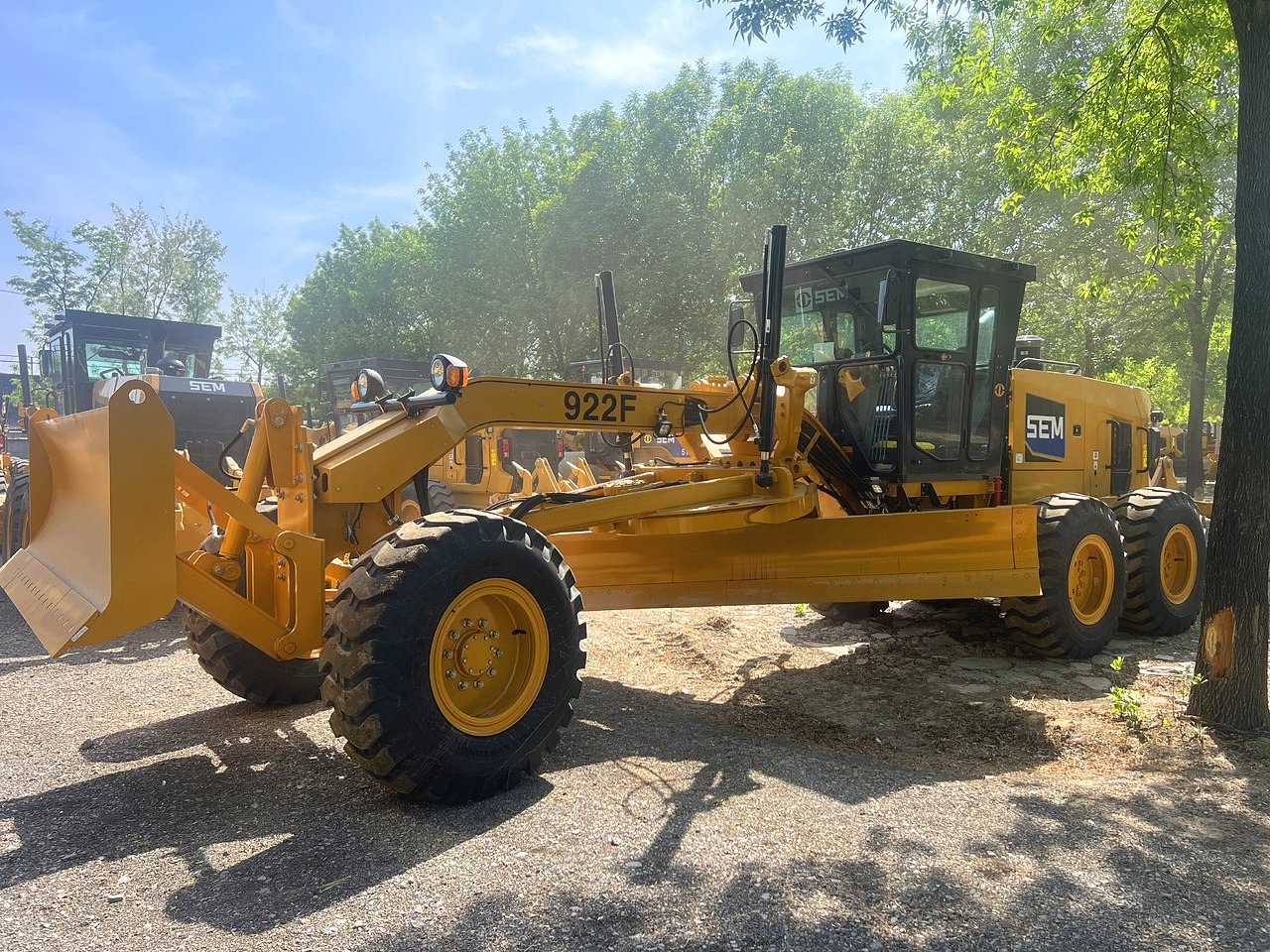 Side view of SEM 922F motor grader, full machine profile with 162kW engine, heavy-duty equipment for road construction and mining.