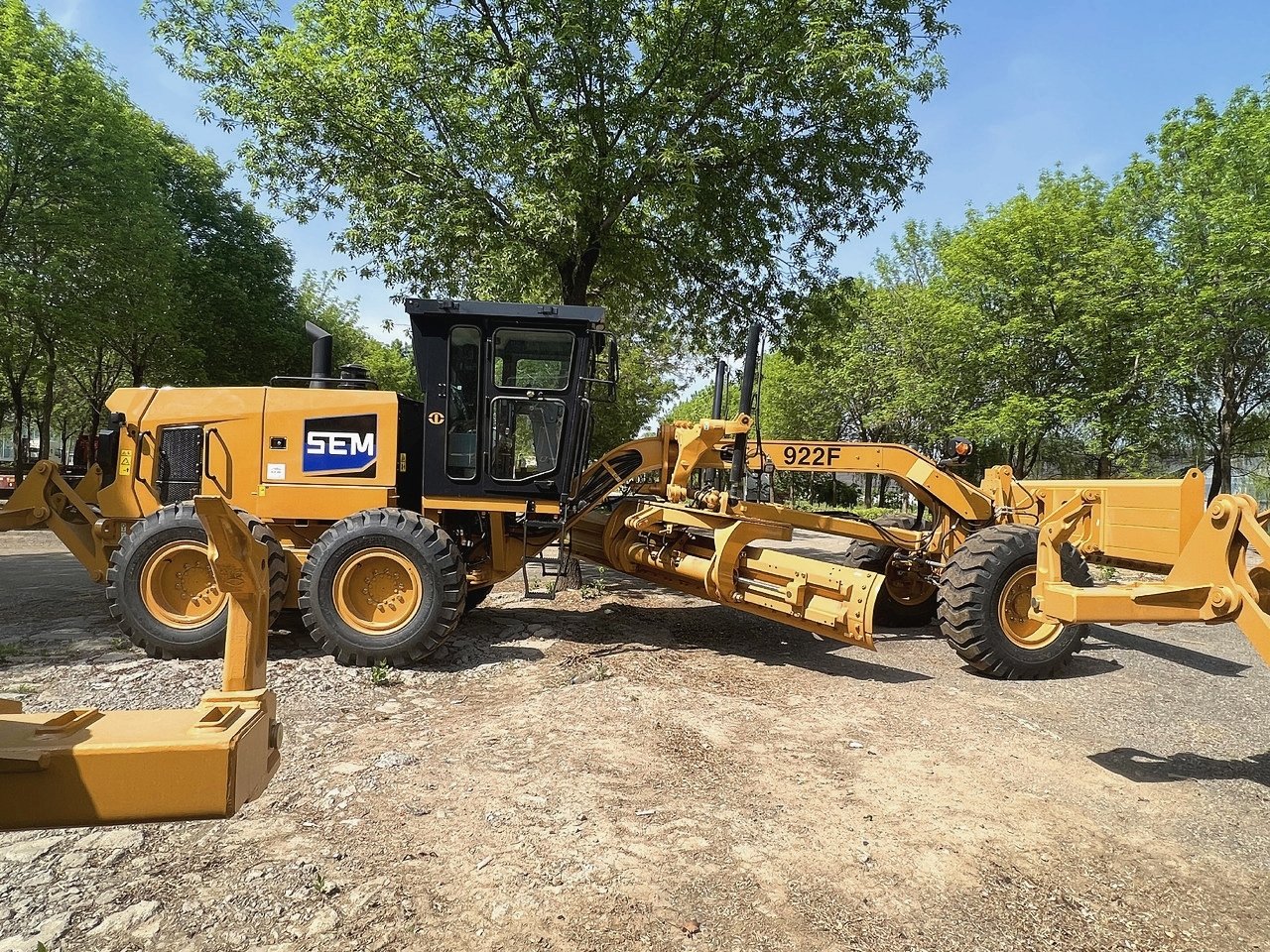 Side view of SEM 922F motor grader, full machine profile with 162kW engine, heavy-duty equipment for road construction and mining.