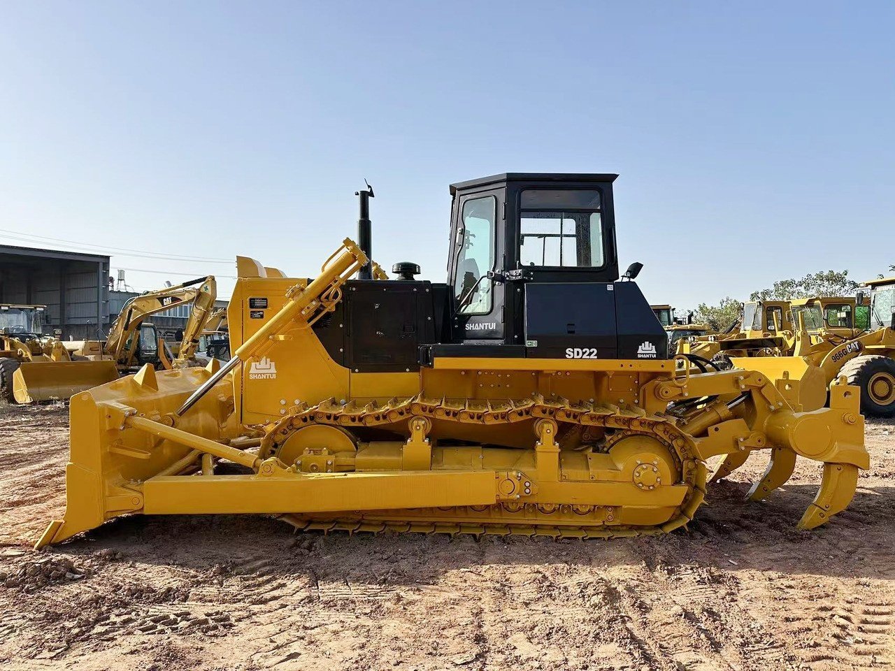 Side view of Shantui SD22 bulldozer showing long crawler tracks, straight blade, and heavy-duty structure for earthmoving and construction work