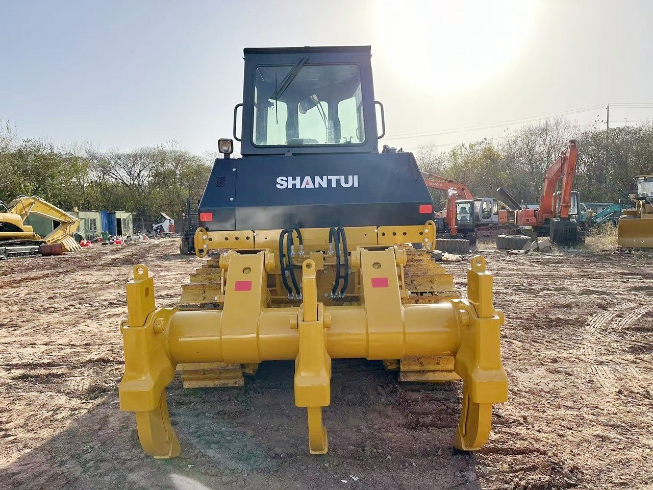 Rear view of Shantui SD22 bulldozer highlighting engine housing, rear chassis, and crawler tracks for heavy-duty earthmoving work