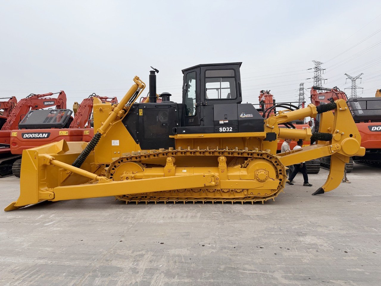 Side view of Shantui SD32 bulldozer showing crawler tracks, long undercarriage, and heavy-duty blade for mining operations