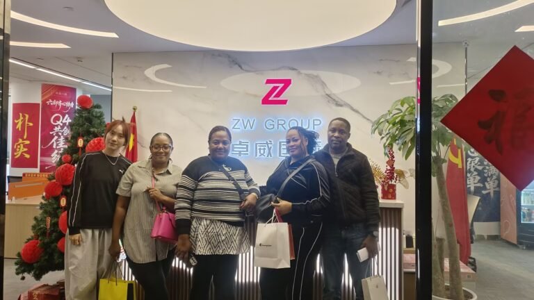 Customers and ZW Group representatives taking a group photo at the company entrance after a successful visit and business meeting.