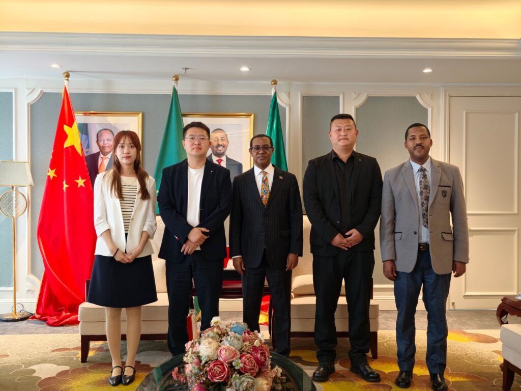 ZW Group leadership (Ivan Sun, Pierce Guo, Vera Jiang) and an Ethiopian trade delegate pose for a group photo with Ethiopian Ambassador H.E. Tefera Derbew Yimam in Beijing, discussing heavy truck supply for infrastructure.