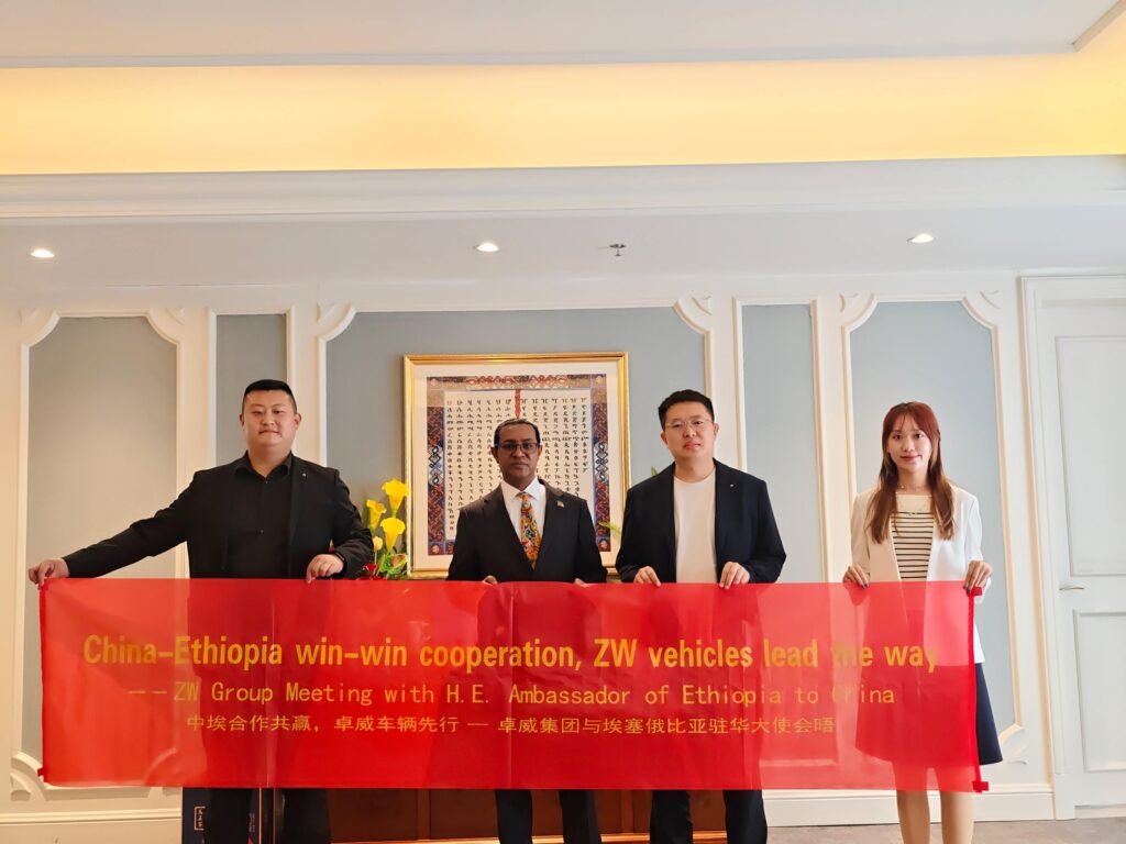 ZW Group Chairman Ivan Sun and leadership team holding a cooperation banner with Ethiopian Ambassador H.E. Tefera Derbew Yimam in Beijing, highlighting ZW vehicles for East African market.