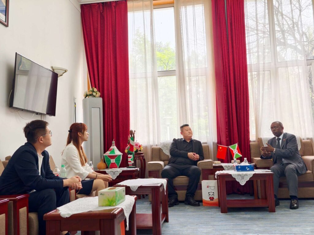 ZW Group executives Ivan Sun, Pierce Guo, and Vera Jiang in a business discussion with Burundi Ambassador H.E. Telesphore Irambona about heavy trucks and construction machinery export solutions.