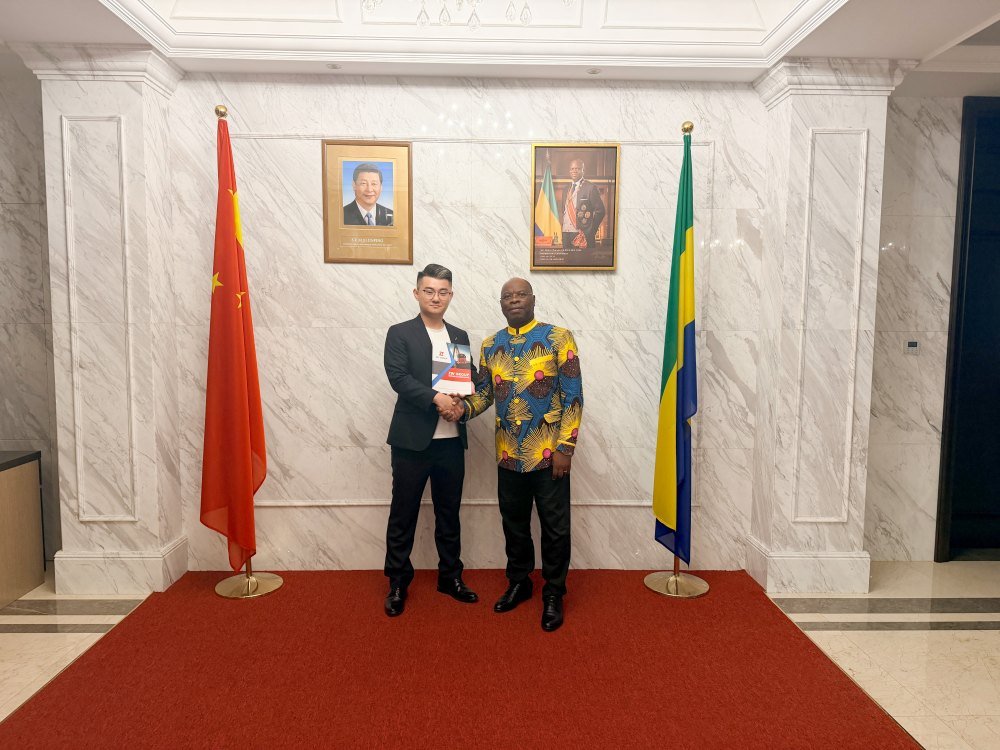 ZW Group representative shaking hands with Gabon Ambassador, showcasing solutions from a reliable Commercial Vehicle Manufacturer China.